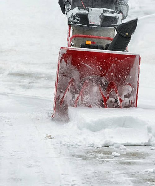 Fresh snow being cleared by a snow blower.